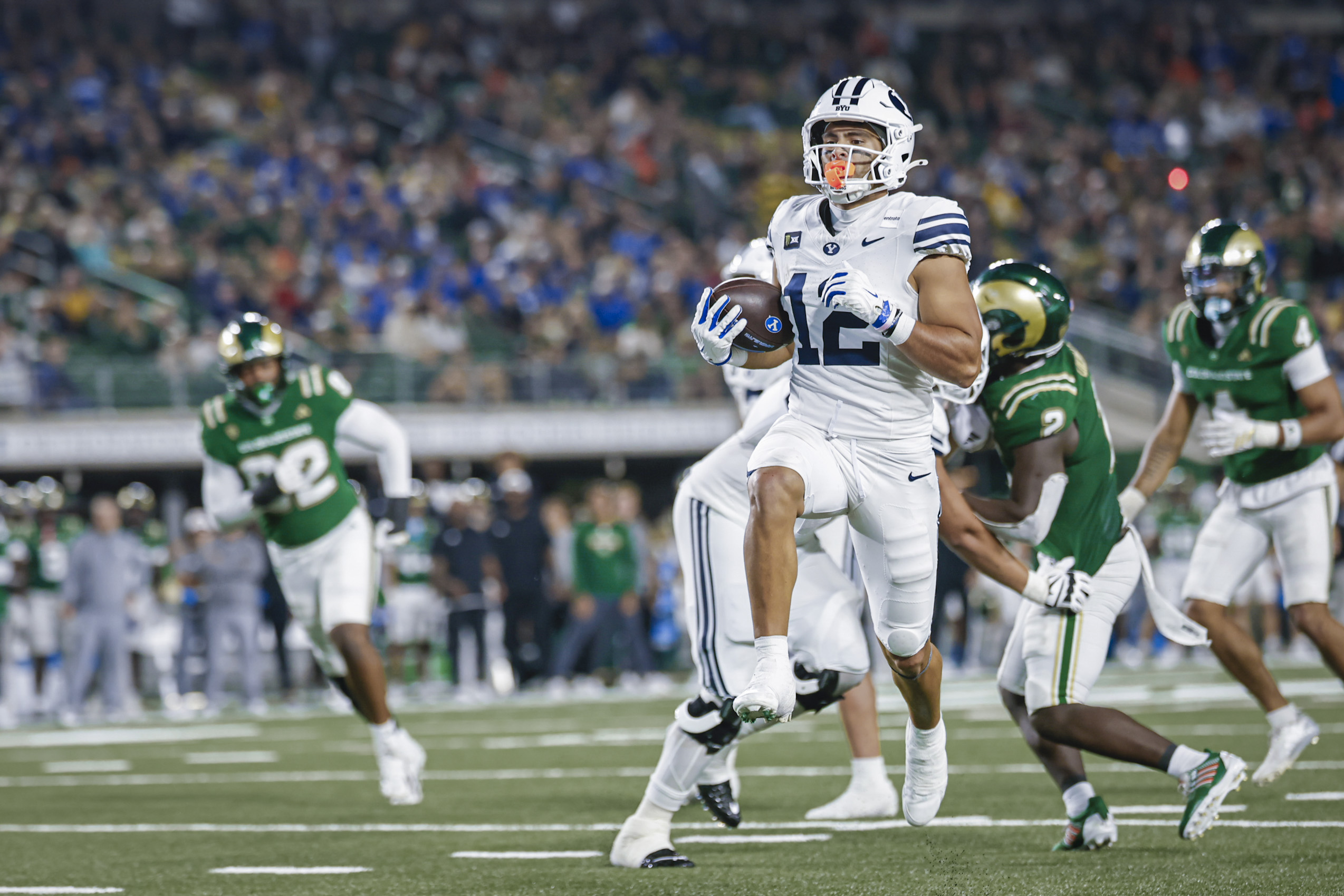BYU receiver accelerating upfield with defenders behind him